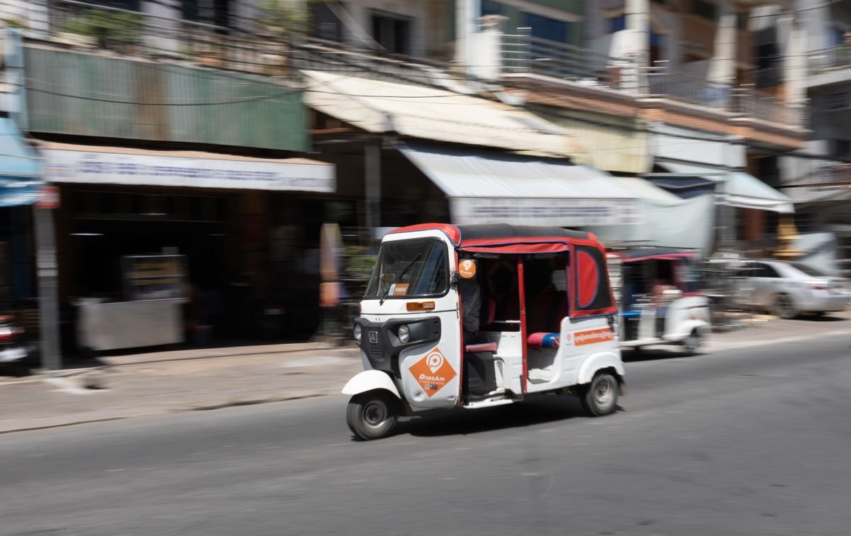 A PassApp auto-rickshaw on a Cambodian street, the enclosed three-wheeler you hail on the app